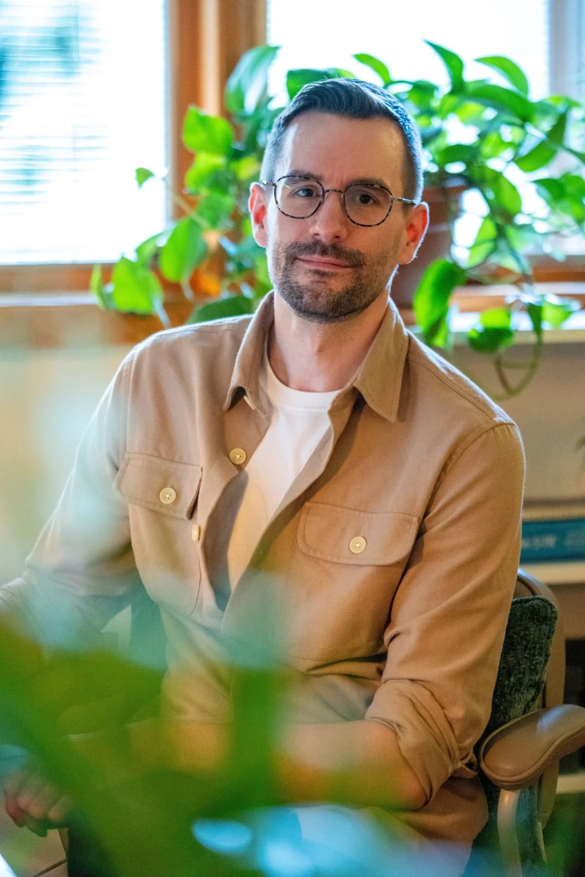 Garrett Gooch in his therapy office surrounded by plants